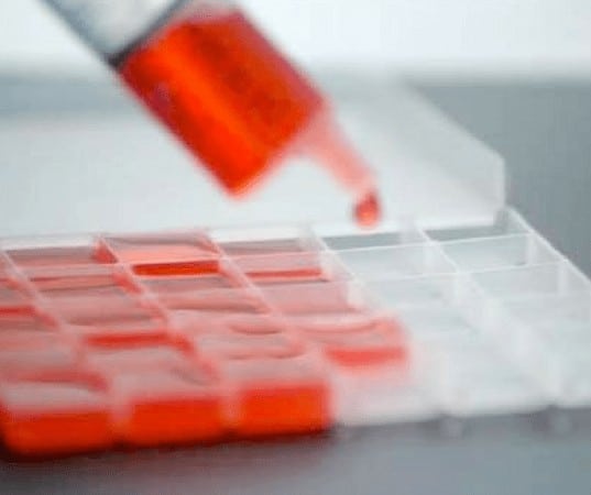 syringe filling small squares with red liquid for refill request