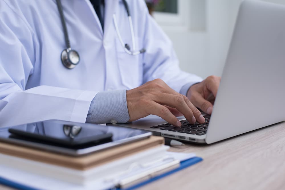 Physician using a laptop to buy TriMix online for a patient