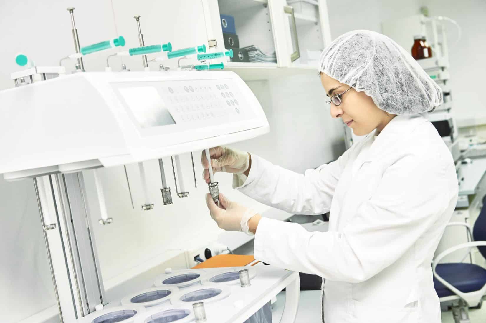 Lab tech filling up bottle in compounding facility