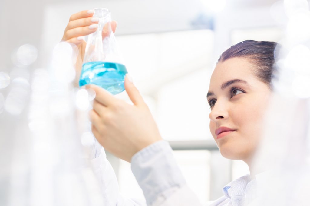 nurse examining a bottle of blue liquid