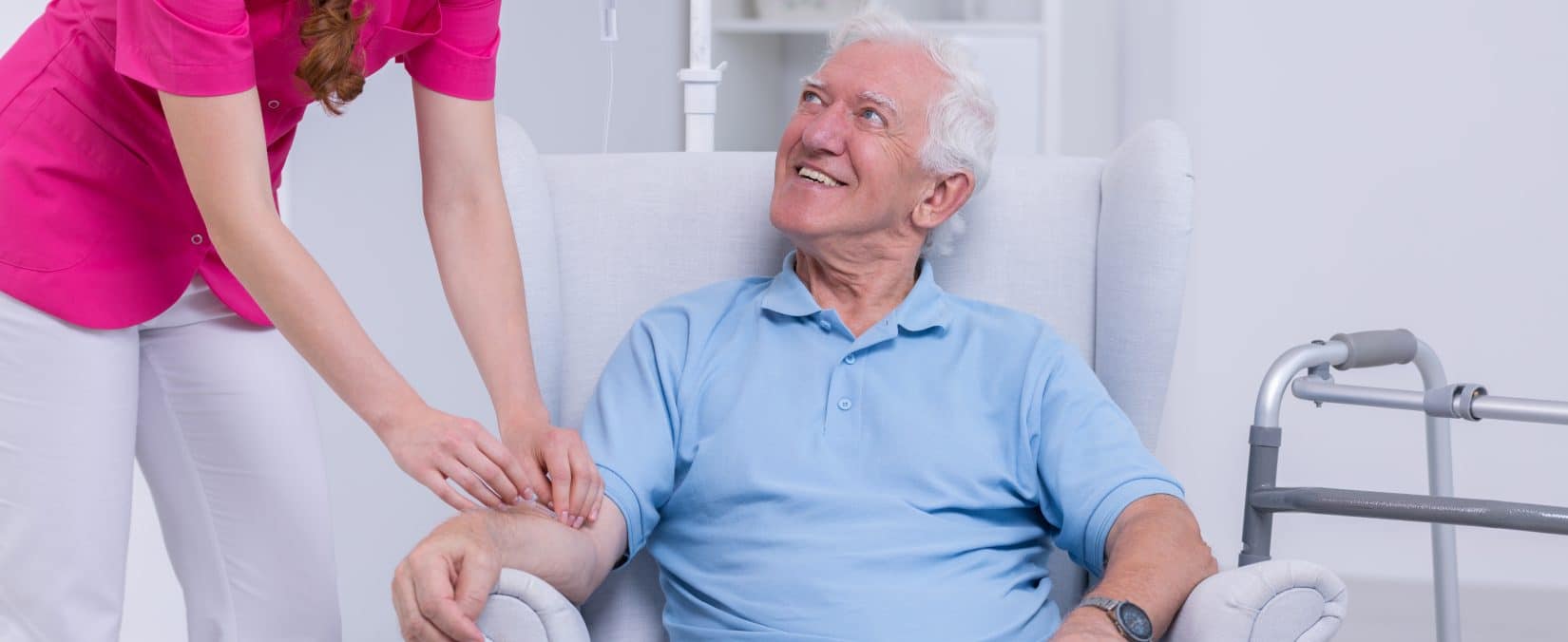 Nurse connecting IV vitamin therapy drip to senior patient