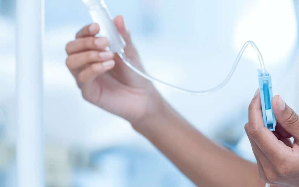 Nurse connecting an IV drip at an IV compounding pharmacy