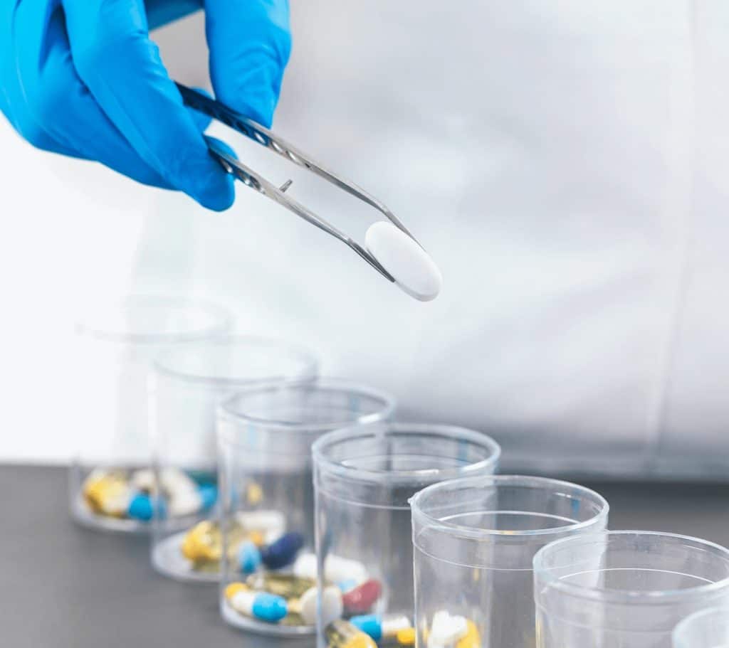 Pharmacist putting pills into clear bottles