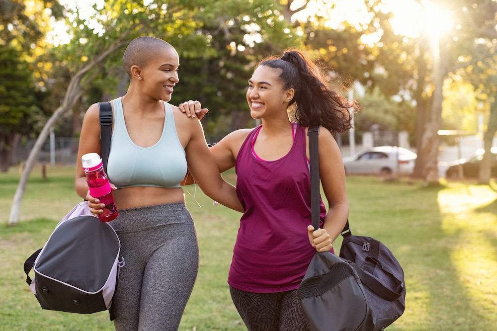 Two women smiling after working out together to maintain a healthy weight
