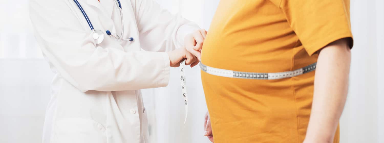 Doctor measuring the waist of an overweight patient