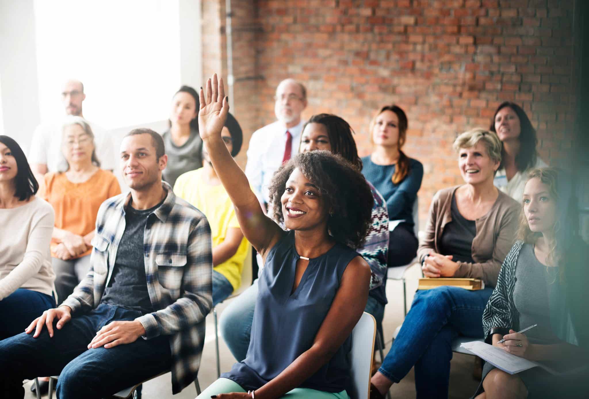 Attendee asking a question at a weight loss clinic seminar