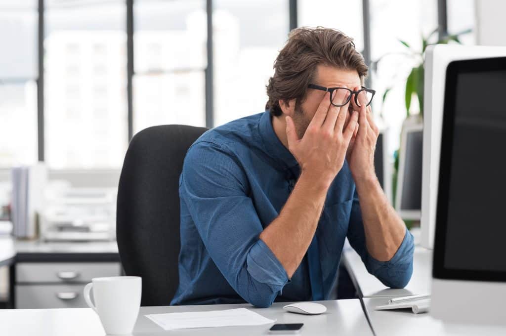 Portrait of an upset businessman with hands over face