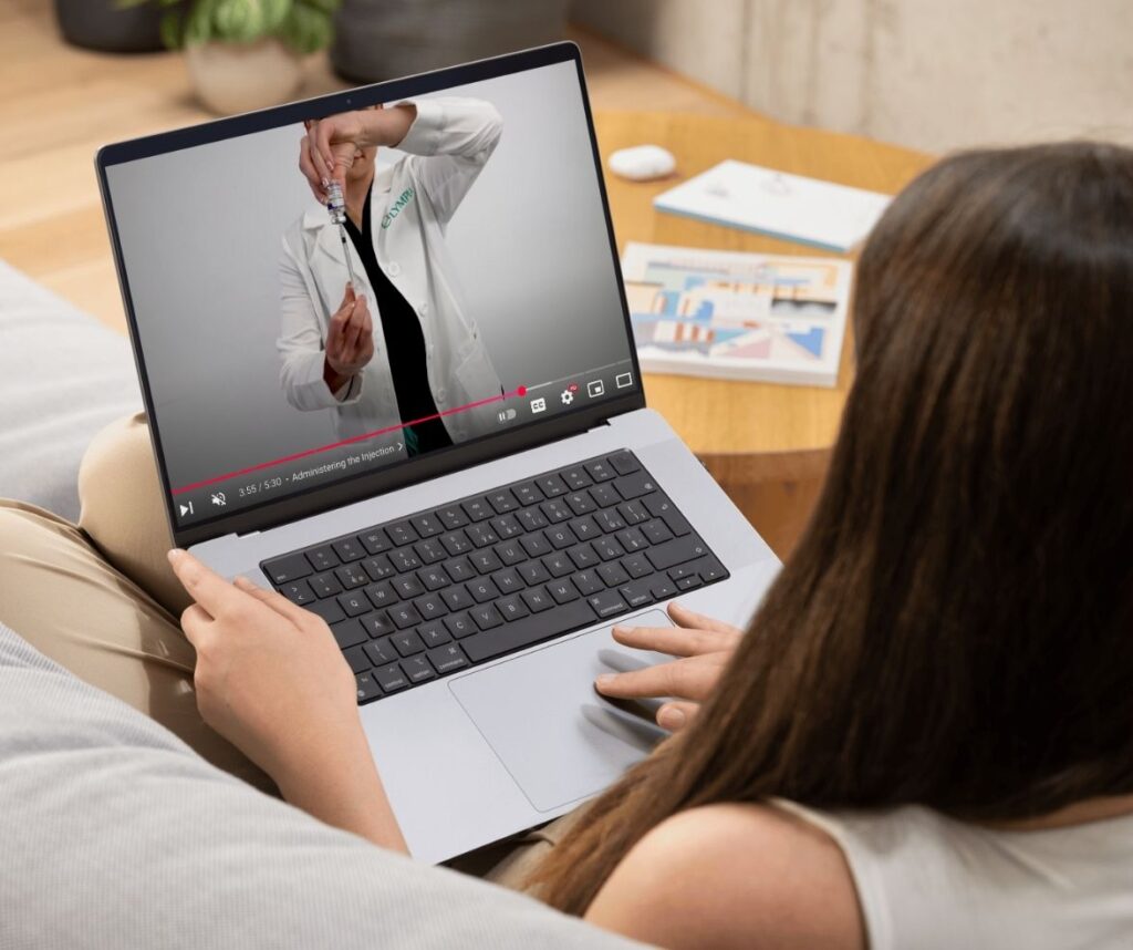 Woman watching a video of a pharmacist showing how to draw from a vial