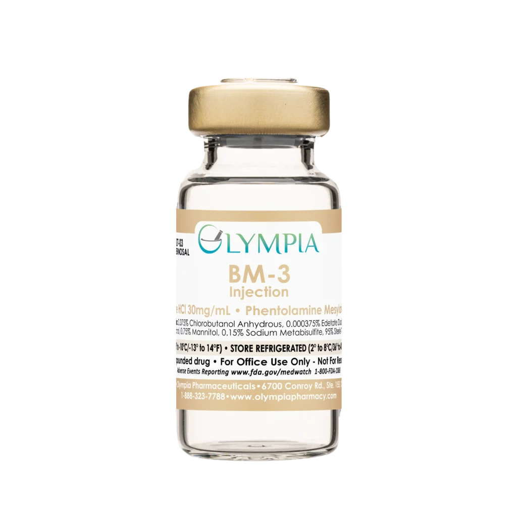 A vial of compounded Bimix ED medication from Olympia. The vial has a gold cap and a gold label that reads "Olympia BM-103 Injection."