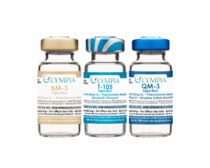 Three vials of compounded Trimix injection vials stand in a line. From left to right, a Bimix vial with a gold cap and label, a Trimix vial with a blue-striped cap and blue label, and a Quadmix vial with a blue cap and blue label.