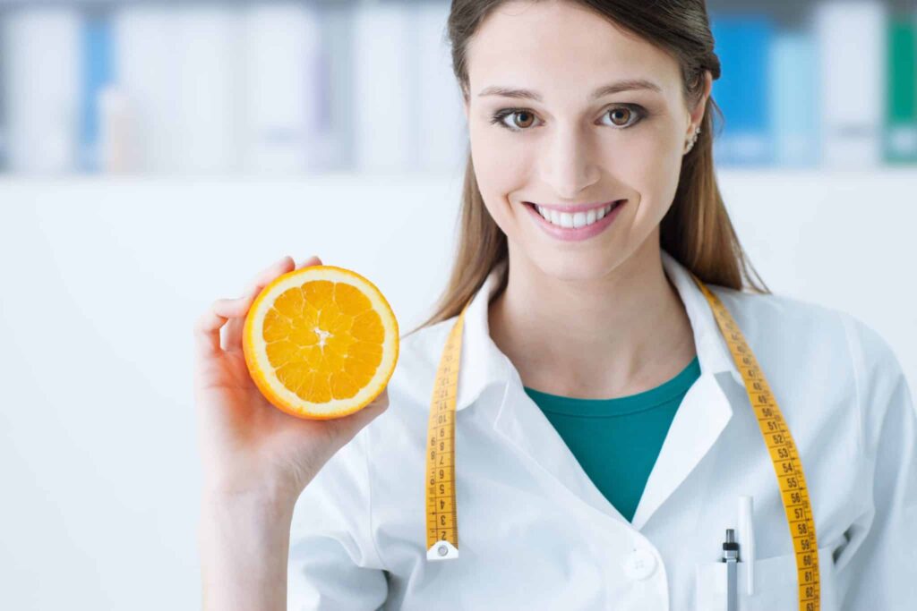 Female Doctor Holding Up an Orange