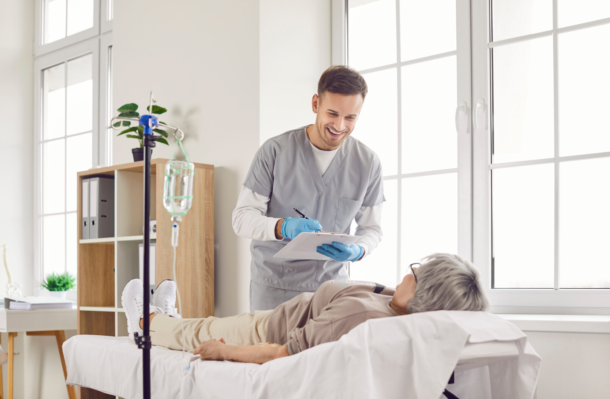 A healthcare professional attends to an elderly patient receiving magnesium chloride IV therapy.